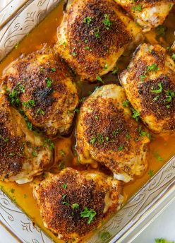 Baked chicken thighs in baking dish.