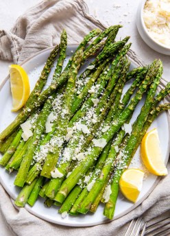 asparagus on a serving plate with lemon and Parmesan cheese