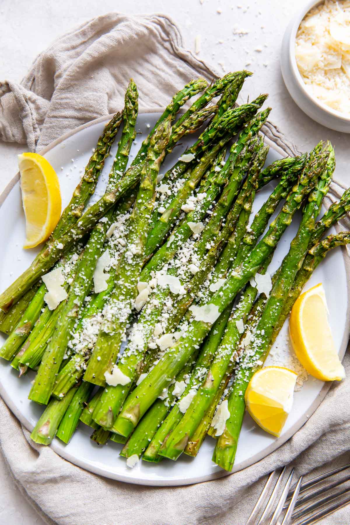 asparagus on a serving plate with lemon and Parmesan cheese