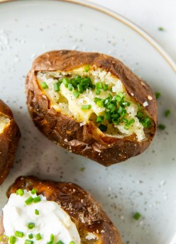 air fryer baked potato topped with butter and chives