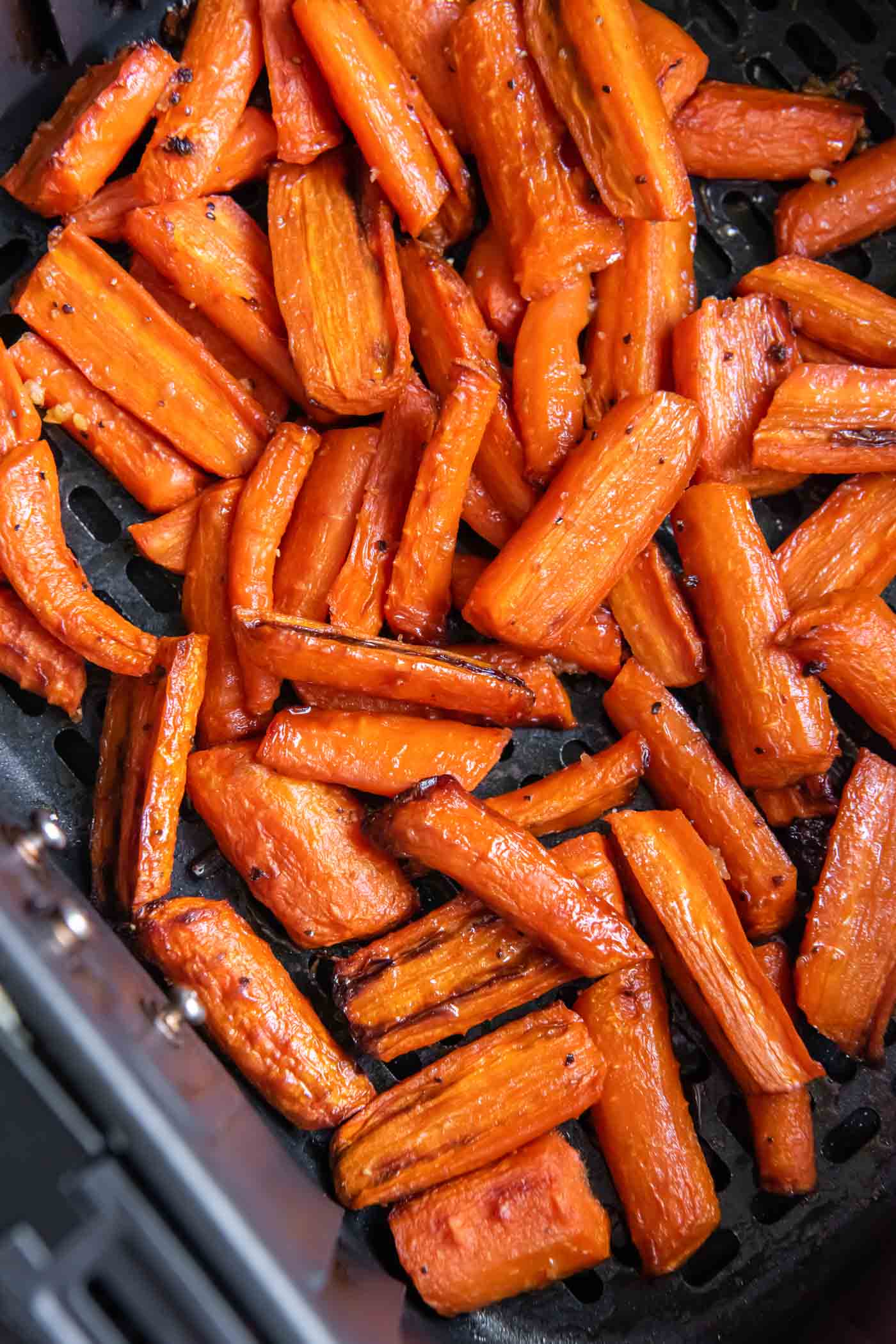 Air fryer carrots with honey garlic butter in air fryer basket.
