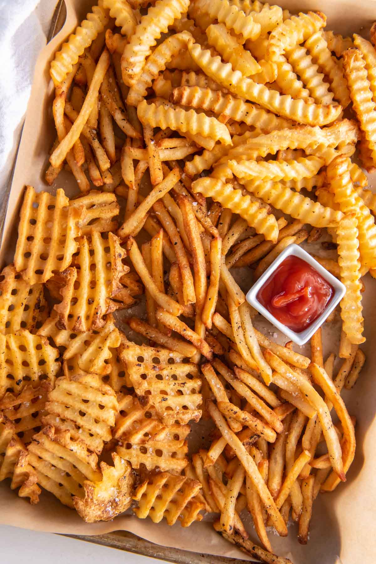 Shoestring, crinkle cut and waffle cut fries served with small dish of ketchup.