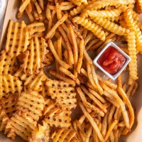 Crinkle cut, waffle and regular air fryer frozen french fries served with ketchup.