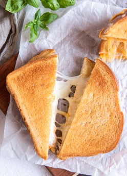 Air fryer grilled cheese sandwich cut in half showing melty cheese.
