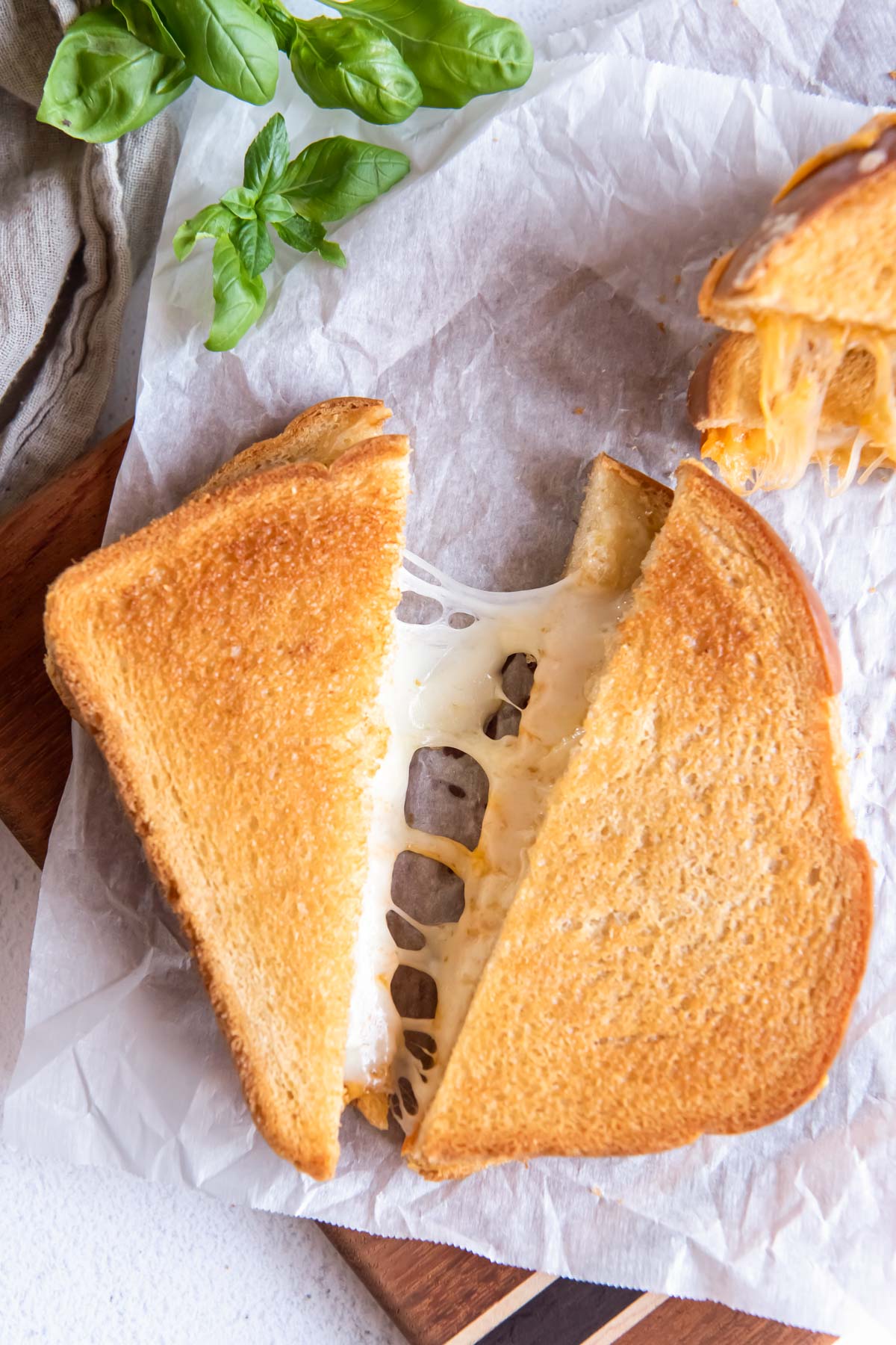 Air fryer grilled cheese sandwich cut in half showing melty cheese.