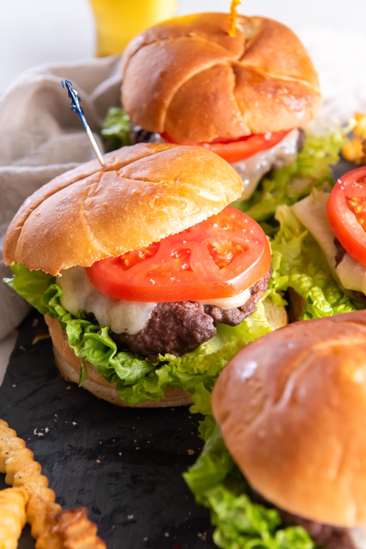 Air fryer hamburgers served on buns with cheese, lettuce and tomato.