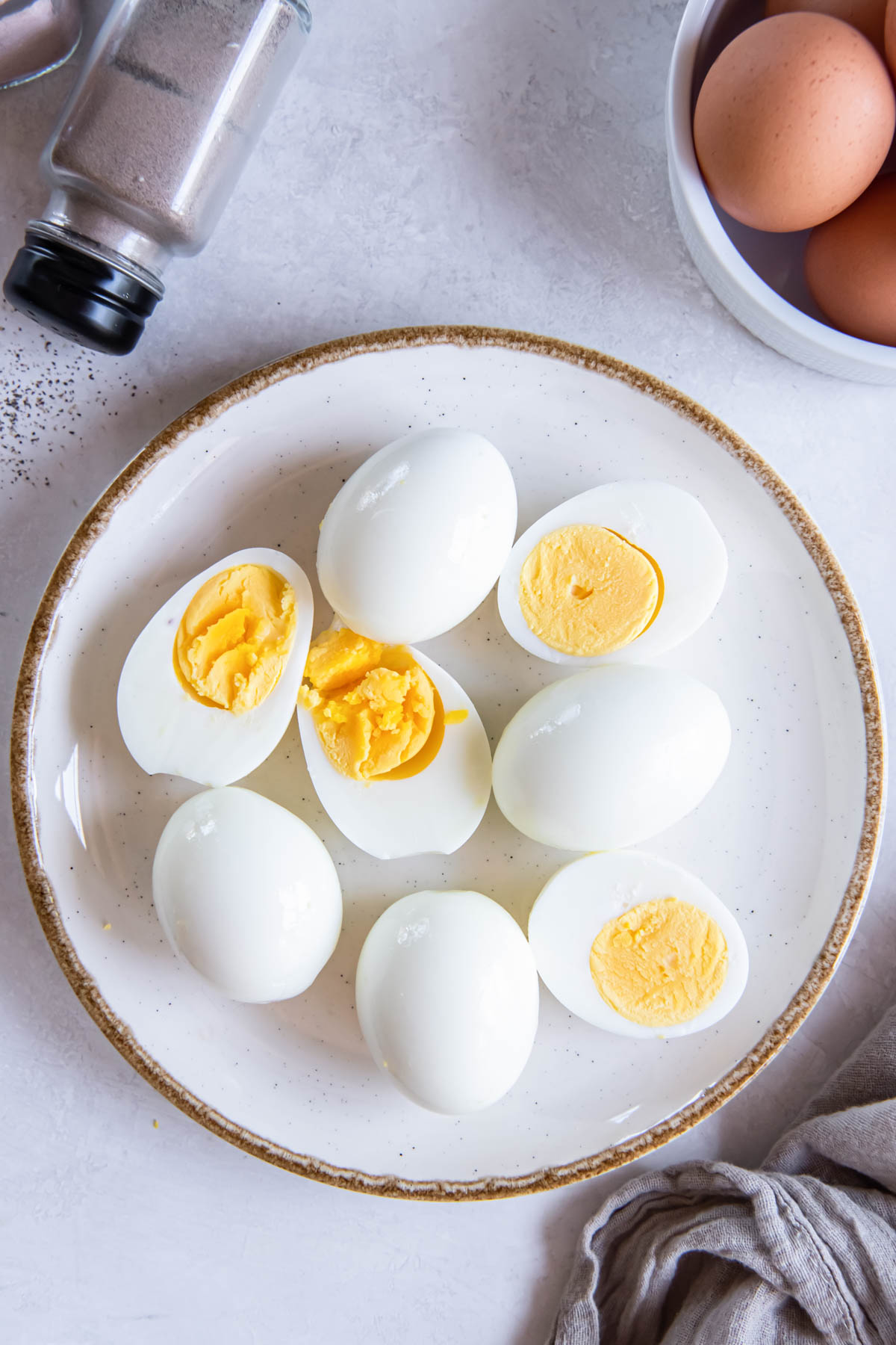 Air fryer hard boiled eggs on a plate with some eggs whole and some cut in half.