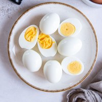 Peeled hard boiled eggs with some whole and some cut in half.