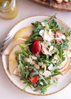 Arugula salad with pear and parmesan served on a plate.