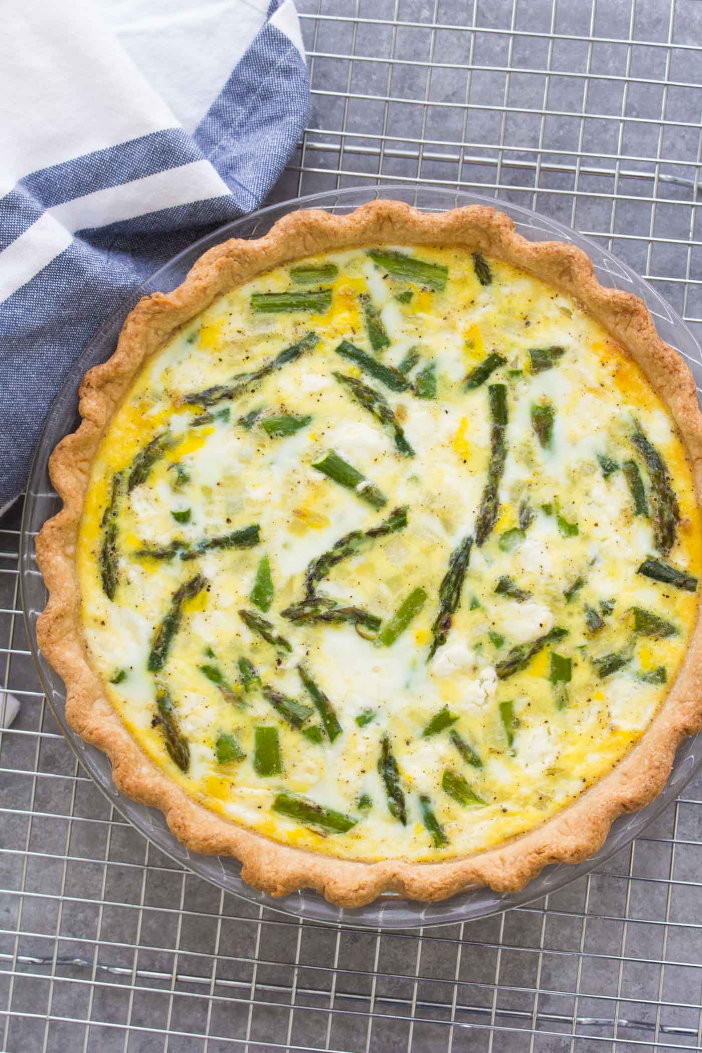 Whole asparagus quiche on a cooling rack.