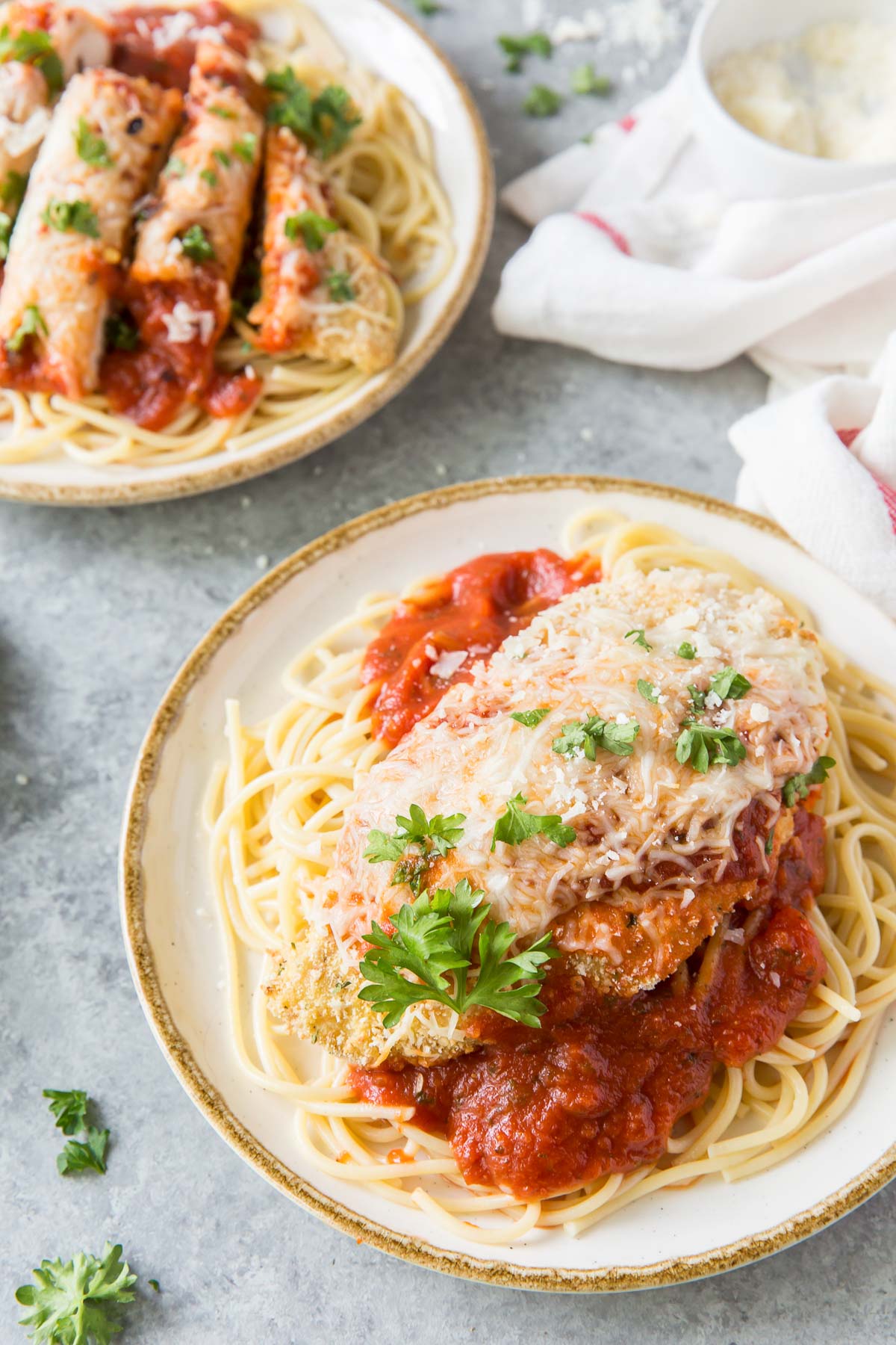 Chicken parmesan served over spaghetti with marinara.