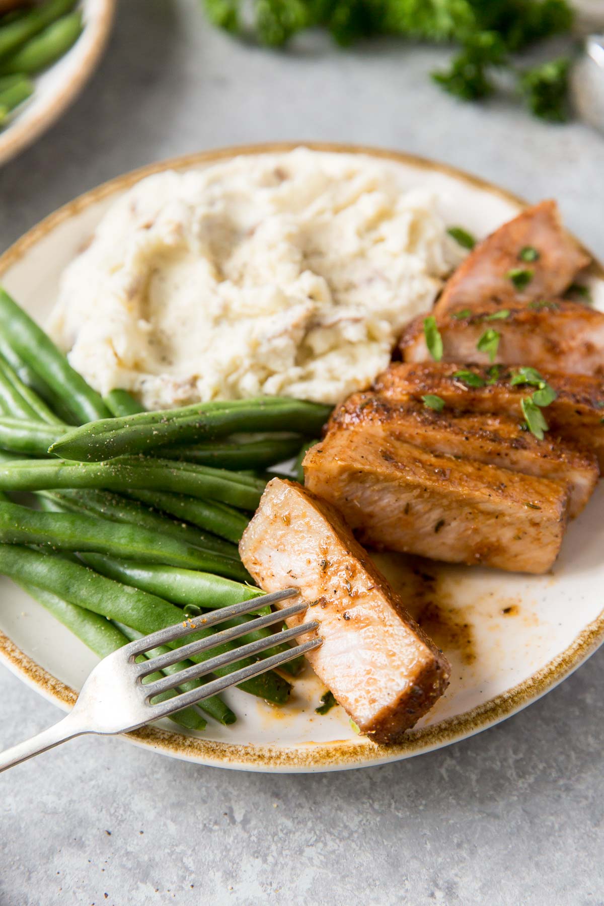 baked pork chop served with green beans and mashed potatoes