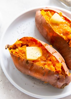 two baked sweet potatoes served with butter, salt and pepper