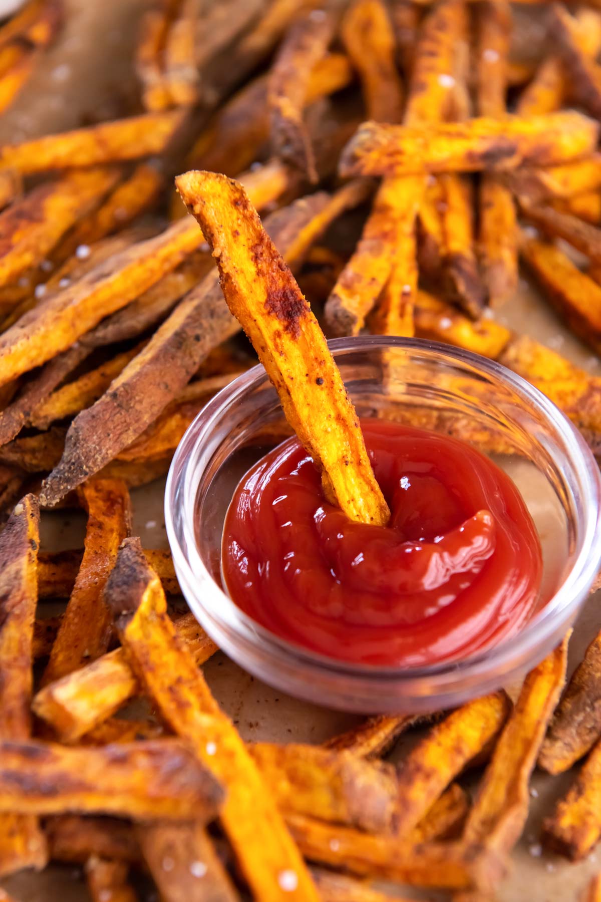 Sweet potato fry dipped in small dish of ketchup.