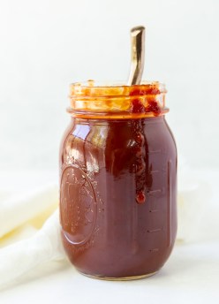 homemade bbq sauce in a mason jar with a spoon