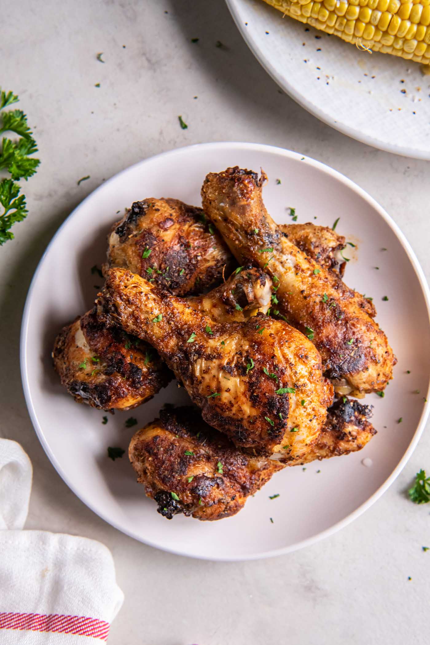 Six baked chicken legs on a plate.