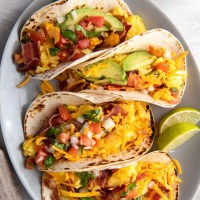 Four breakfast tacos on a plate.