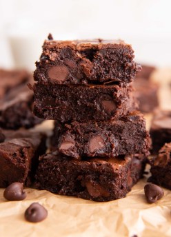 Four fudgy brownies stacked on top of each other.