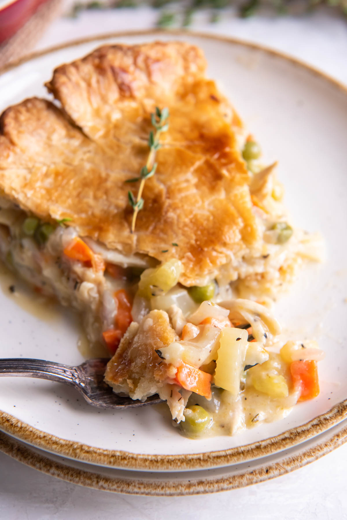 Close up of slice of pot pie with bite on a fork.