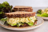 Egg salad sandwich with lettuce on whole wheat bread.