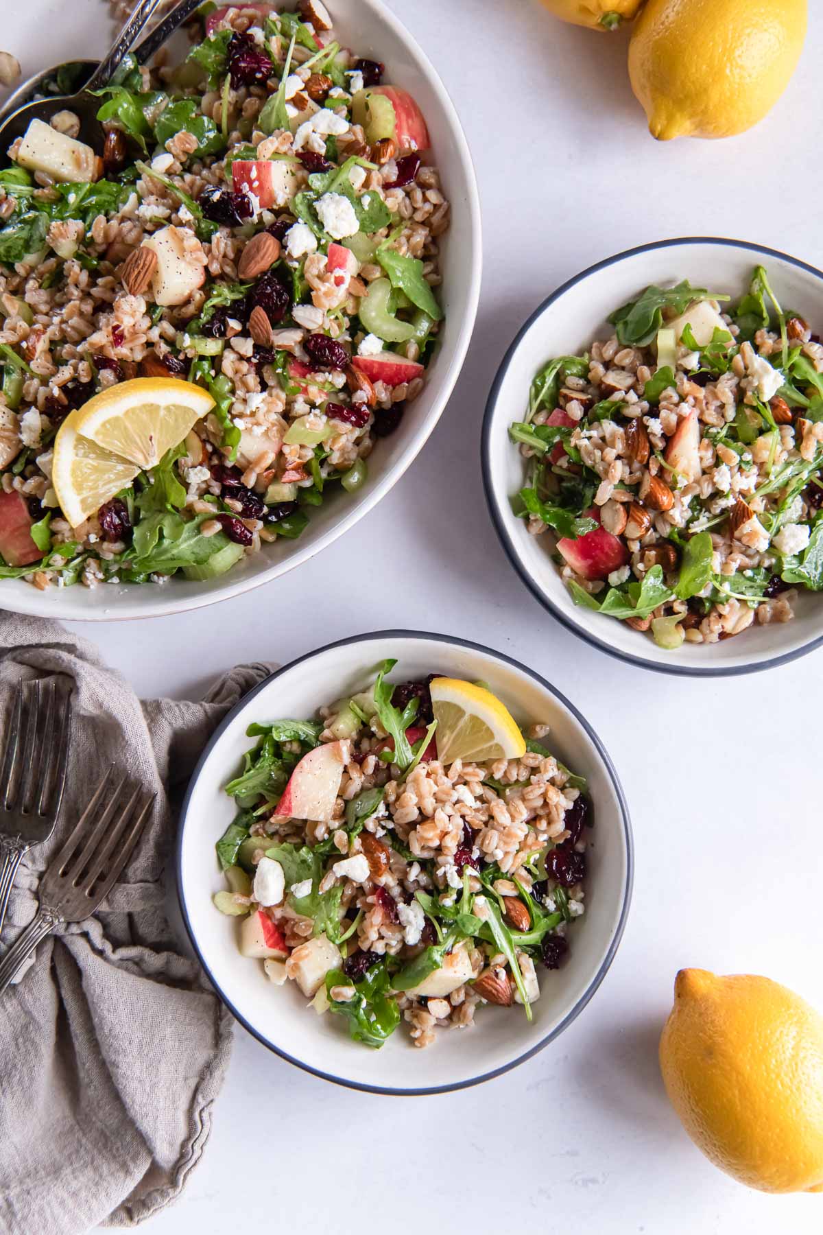 Farro salad in serving bowl and two smaller bowls.