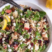 Farro salad with apple, arugula and feta in serving bowl.