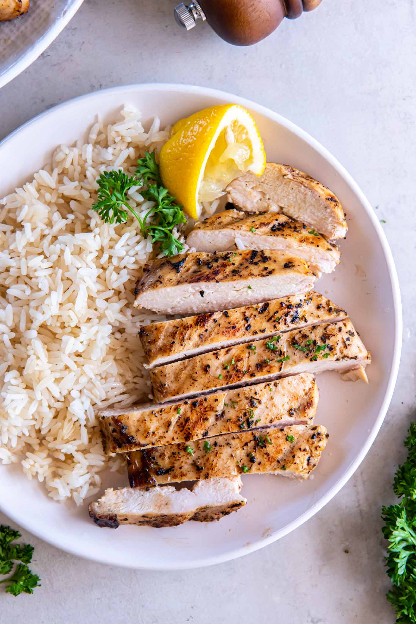 Sliced grilled chicken breast served with rice.