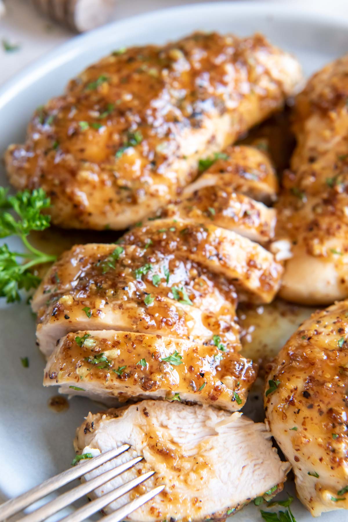 Sliced honey mustard chicken breast on a plate.