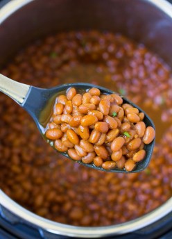A spoonful of baked beans held over an Instant Pot.