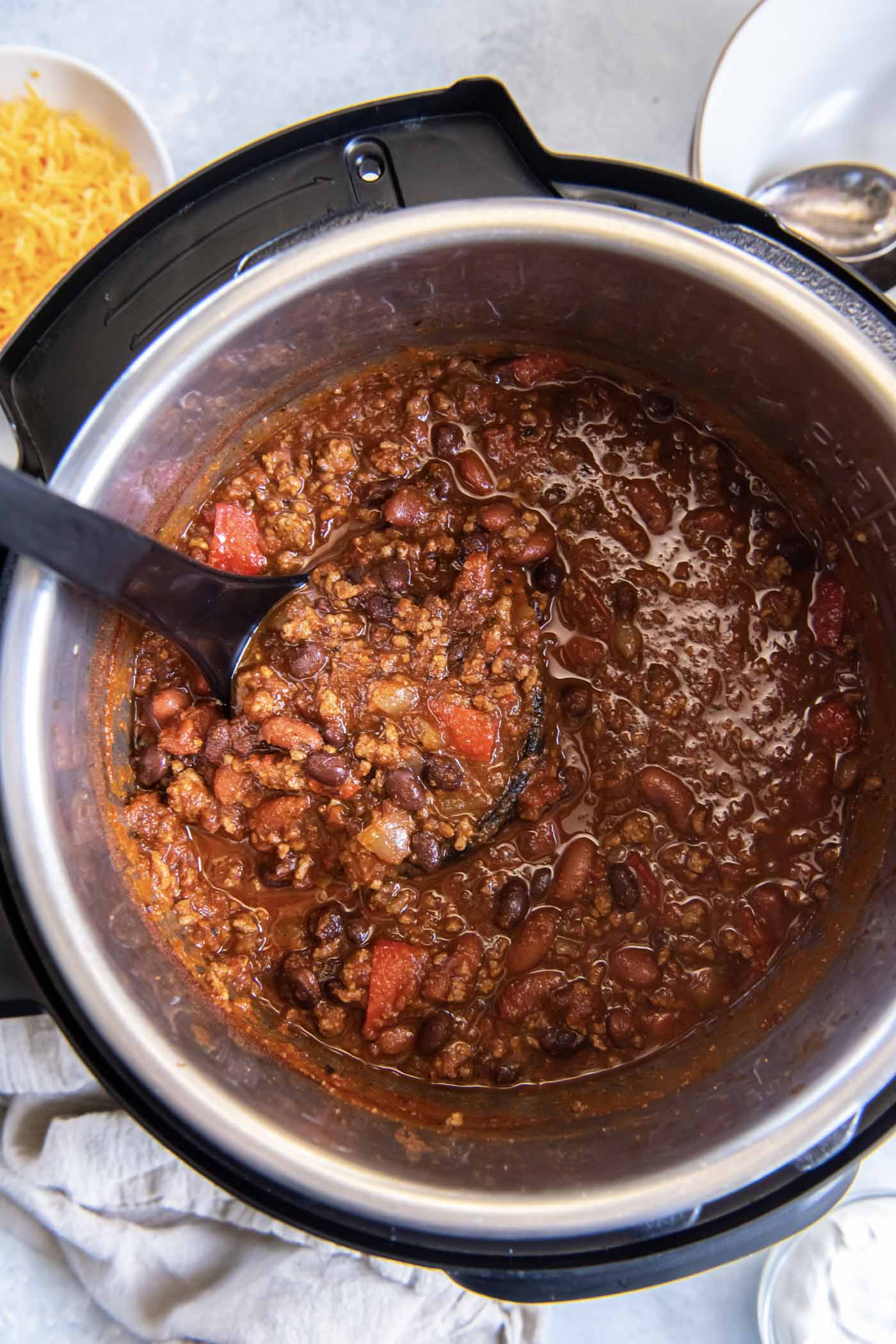 Chili in instant pot with a ladle.