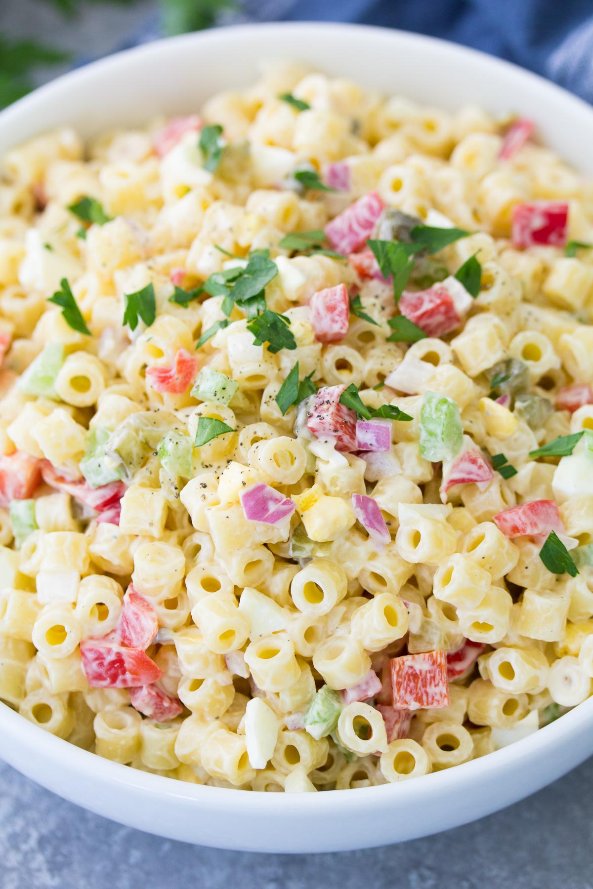 Close up of macaroni salad in a white serving bowl.