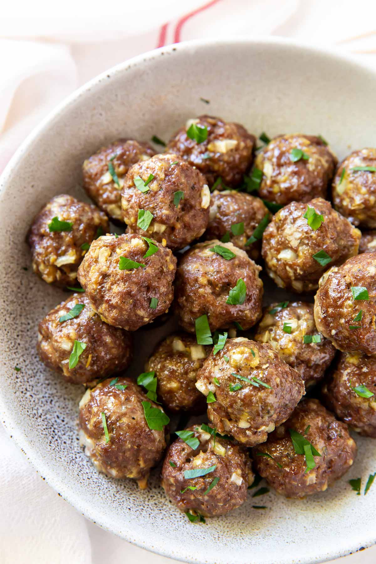 baked meatballs in a serving bowl garnished with parsley