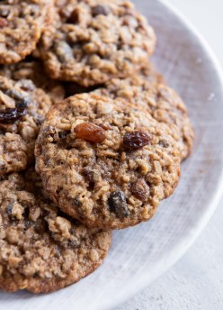 Oatmeal raisin cookies stacked on a plate.