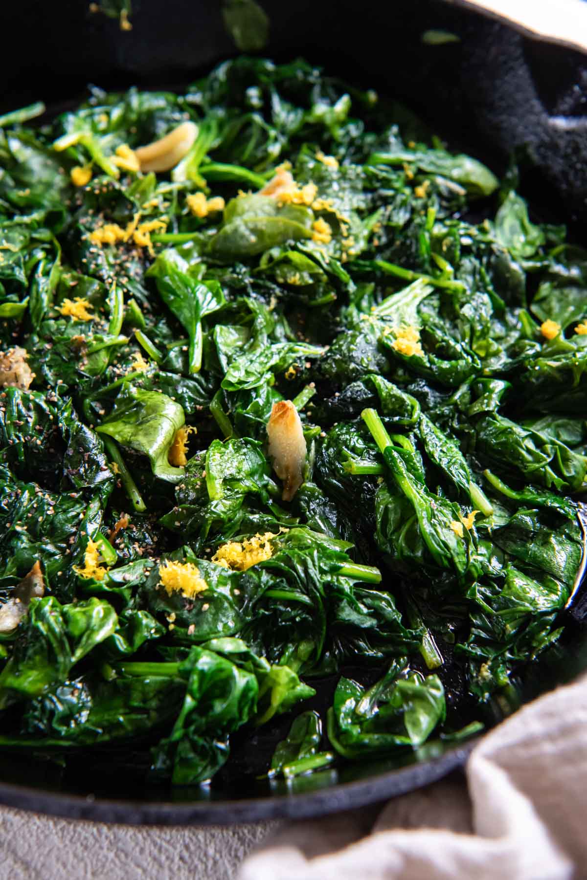 Close up of sautéed spinach in a skillet.
