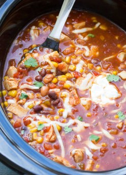 Chicken taco soup in a slow cooker with a serving spoon.