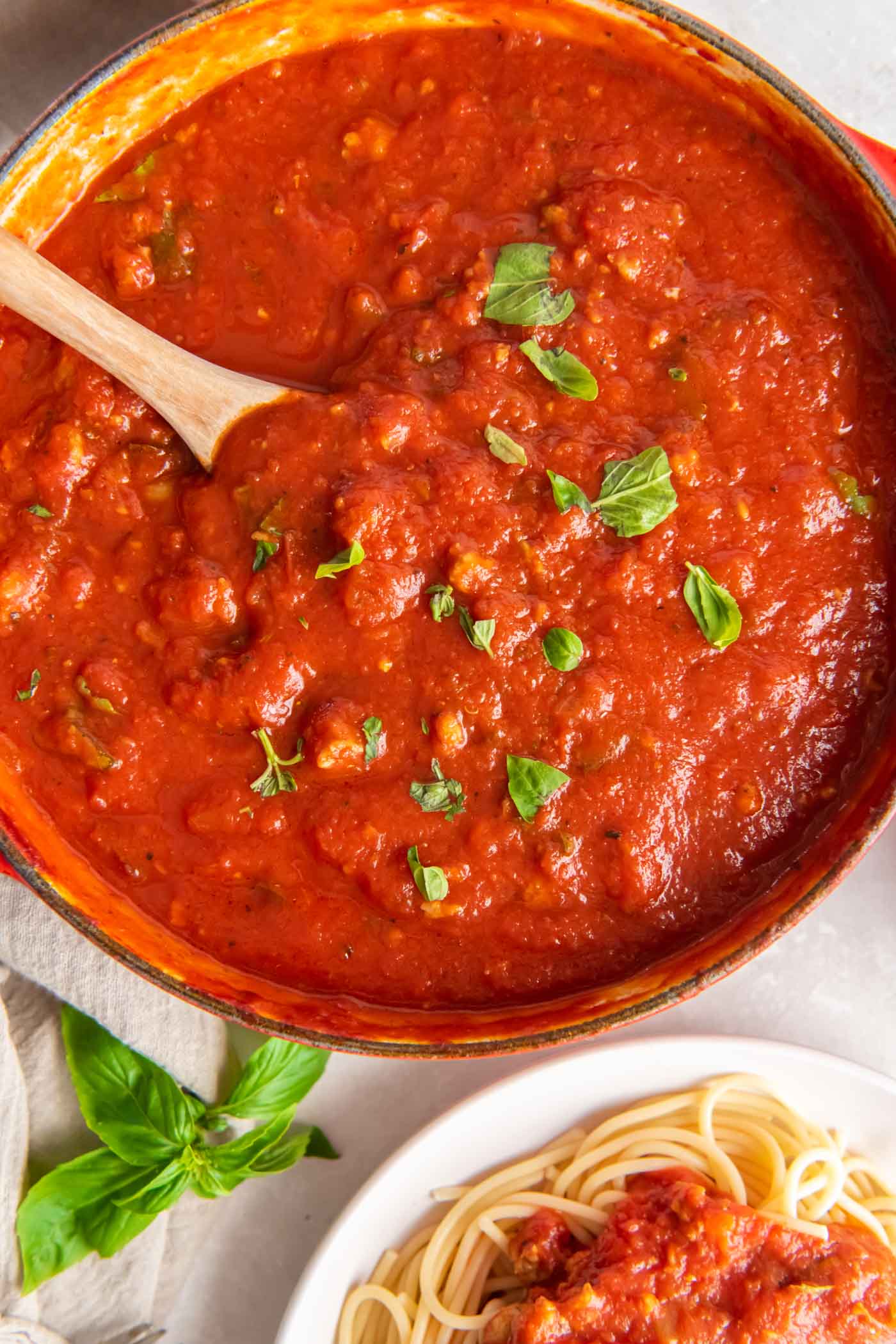 Homemade spaghetti sauce in pot sprinkled with fresh basil.