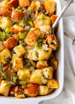Stuffing in baking dish with serving spoon.