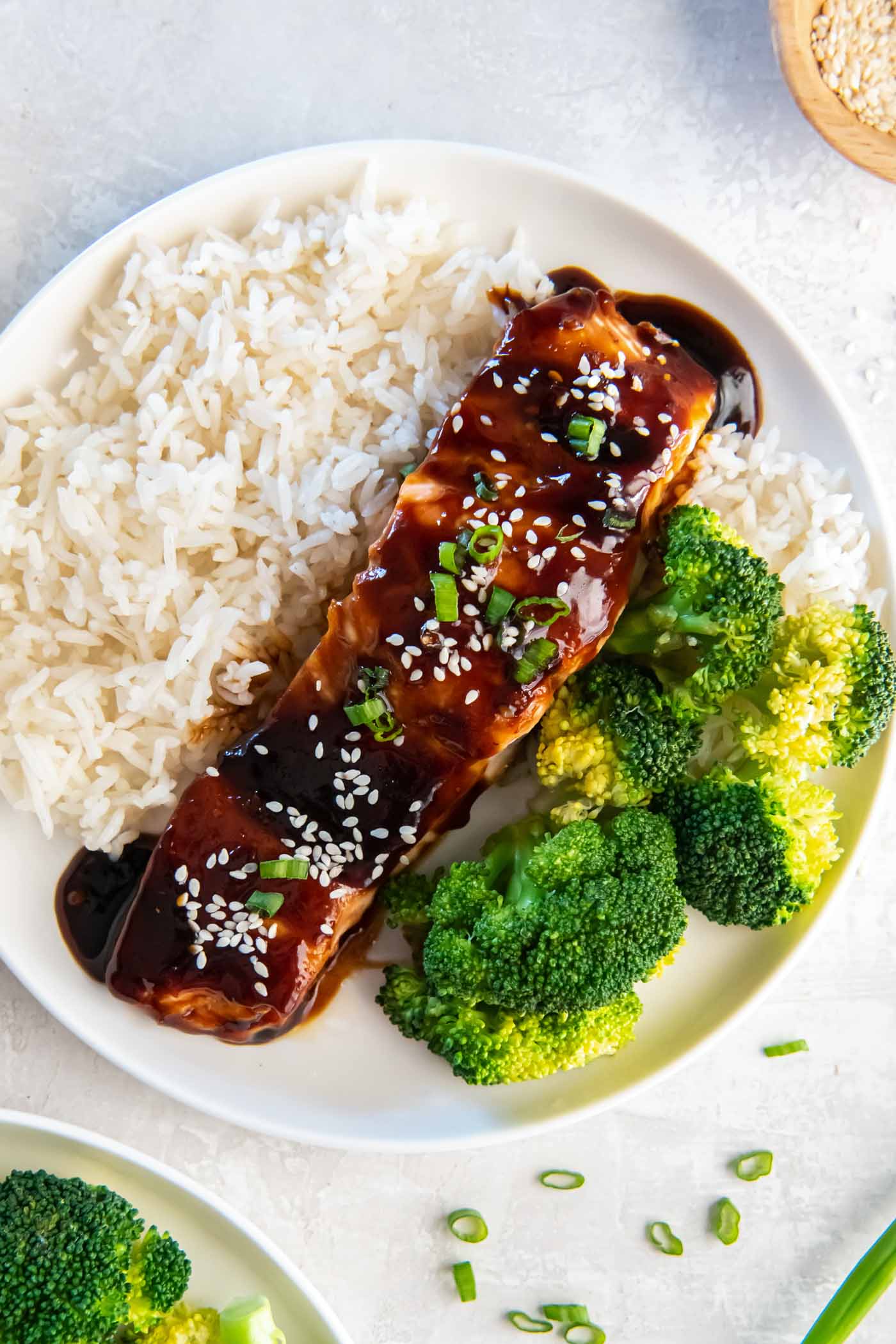 Fillet of teriyaki salmon served with white rice and steamed broccoli.