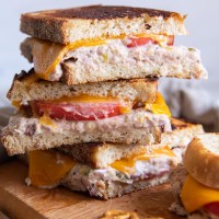 Three tuna melt sandwich halves stacked on top of each other.