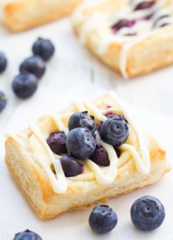 homemade cream cheese danish with icing and topped with blueberries