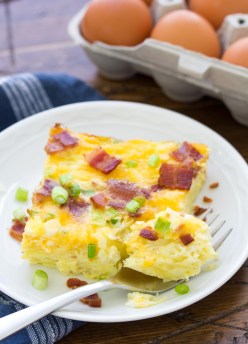 slice of breakfast casserole on a plate with a bite on a fork