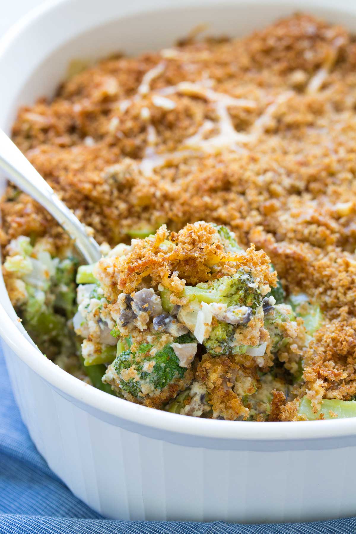 Broccoli casserole in baking dish with serving spoon.