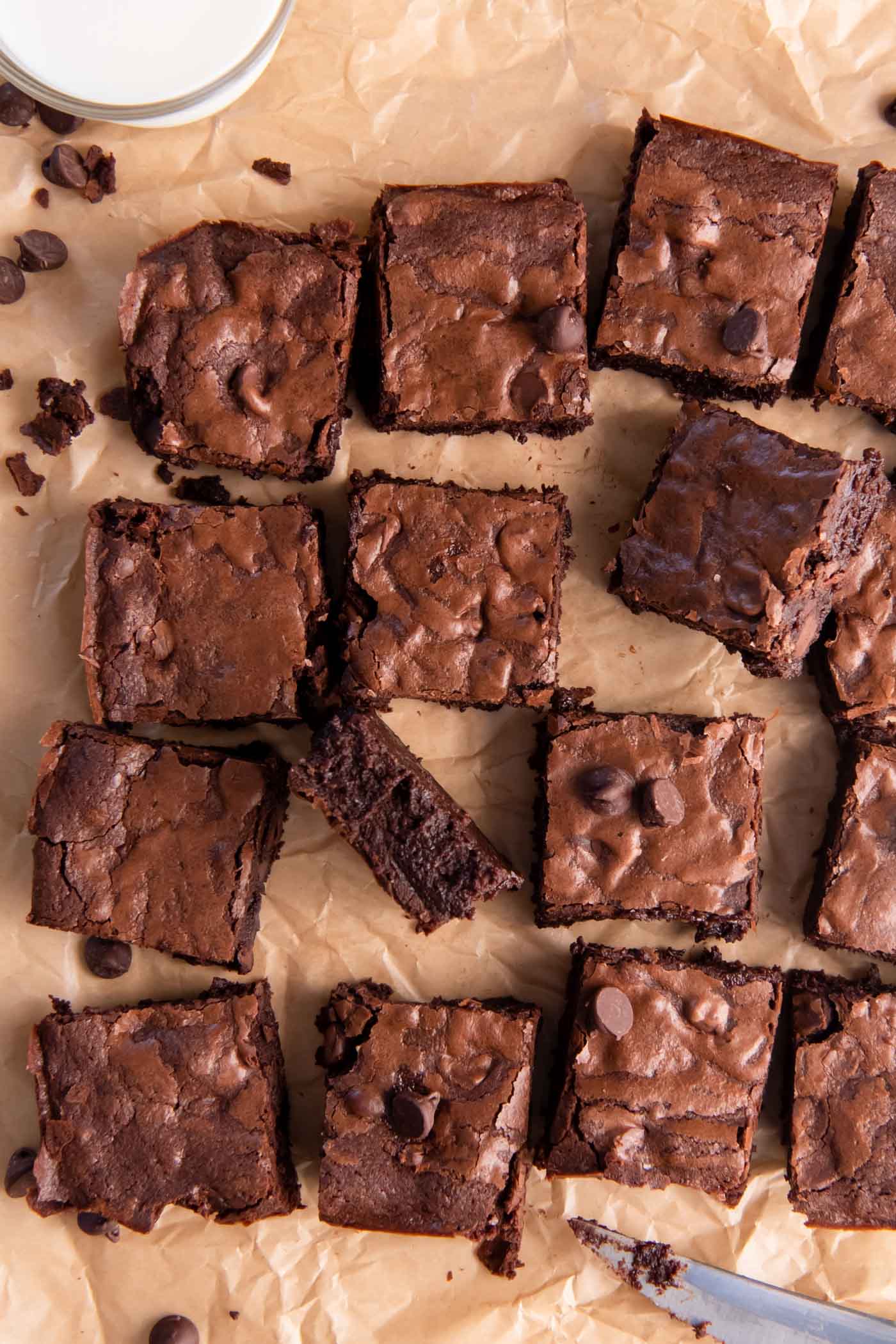 Brownies cut into squares and arranged on a sheet of parchment paper.