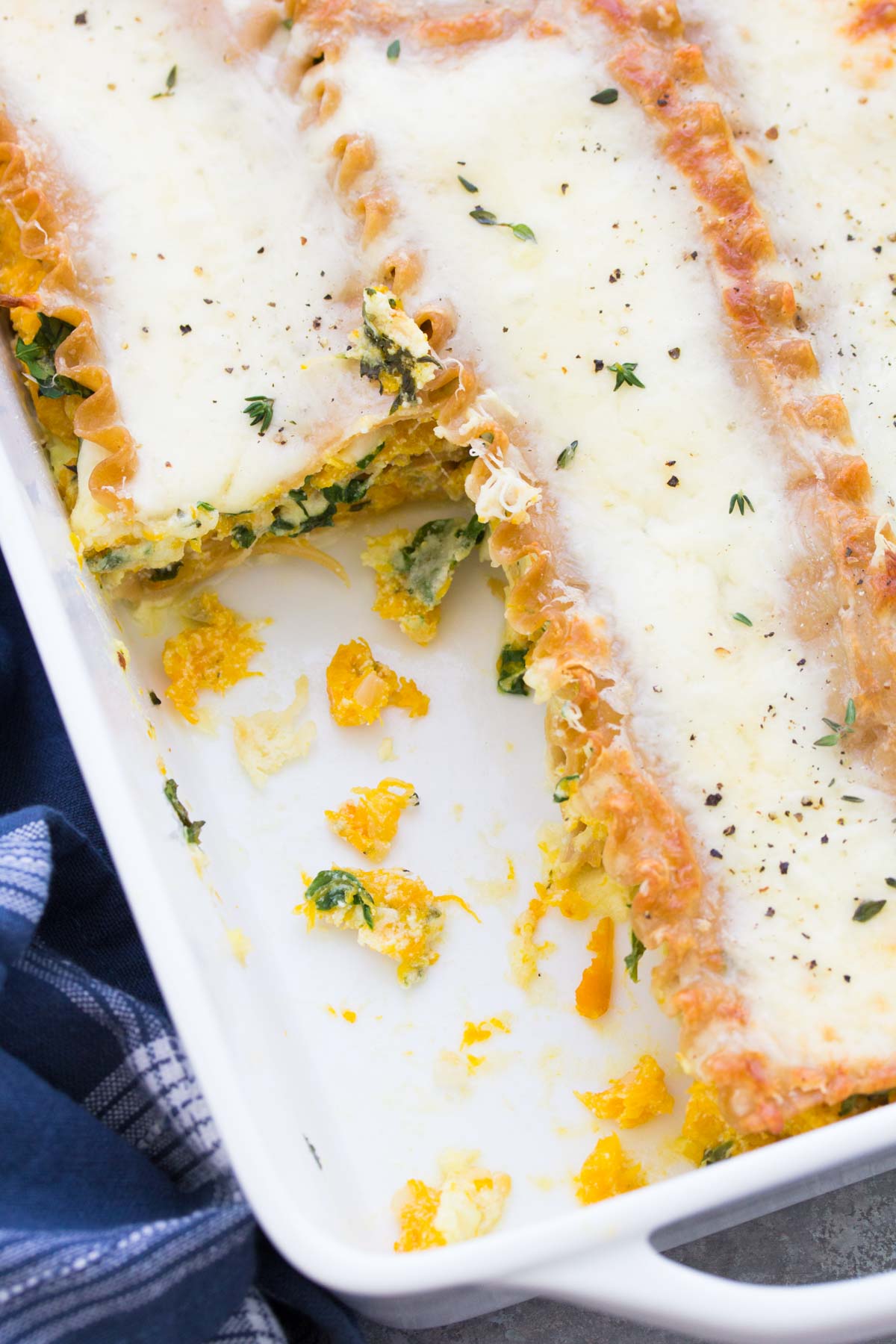 Butternut squash lasagna in baking dish with slice removed.