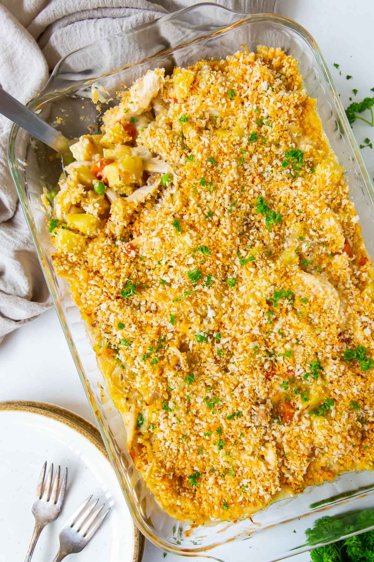 Chicken casserole in a baking dish with a serving spoon.