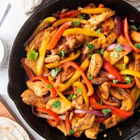 Cooked chicken fajitas in a cast iron skillet.