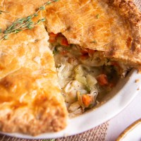 Whole chicken pot pie with a slice removed.