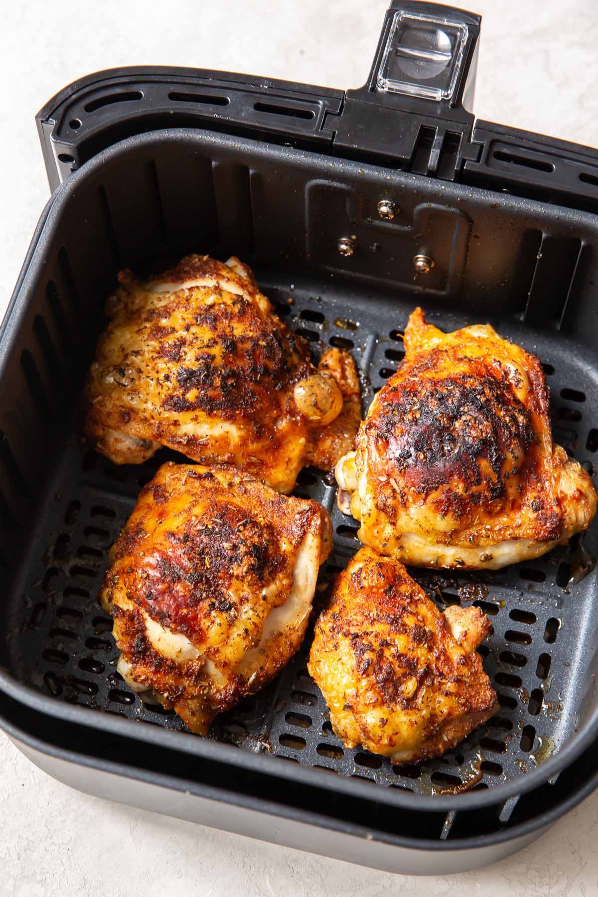cooked crispy chicken thighs in air fryer basket