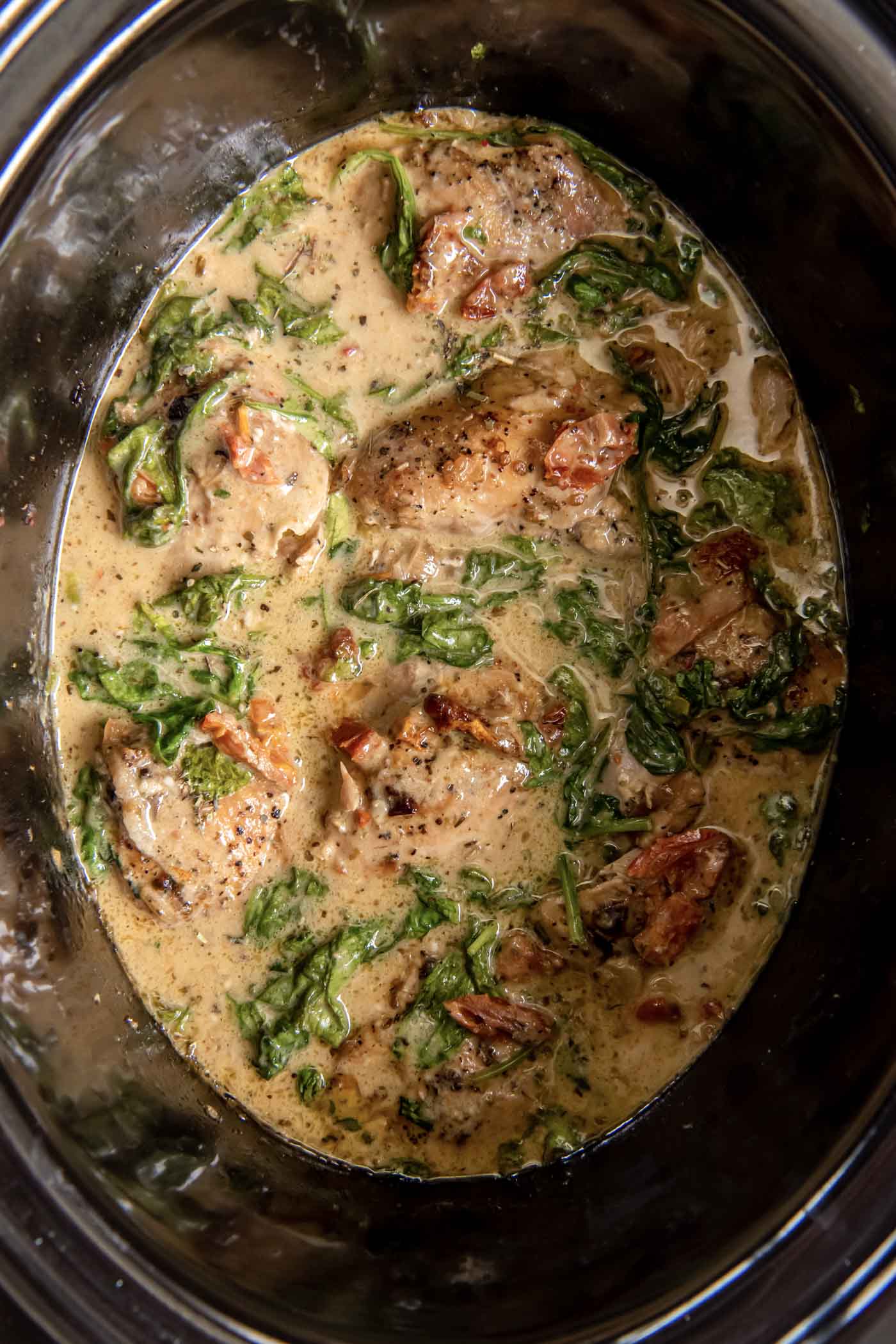 Chicken thighs in a creamy Tuscan sauce in the slow cooker.