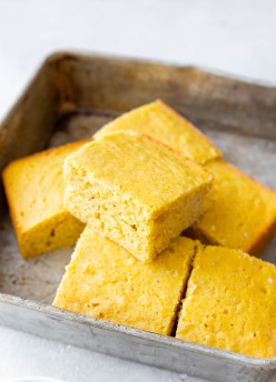 slices of cornbread stacked in baking pan